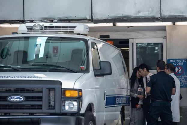 عمال مستشفى وسيارة إسعاف قرب مكتب الفحص الطبي الرئيسي في مدينة نيويورك الذي نقل إليه جثمان الملياردير جيفري إيبستين. تصوير: جيناه مون - رويترز.